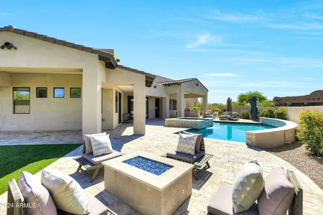 a view of a patio with couches table and chairs with wooden floor and fence