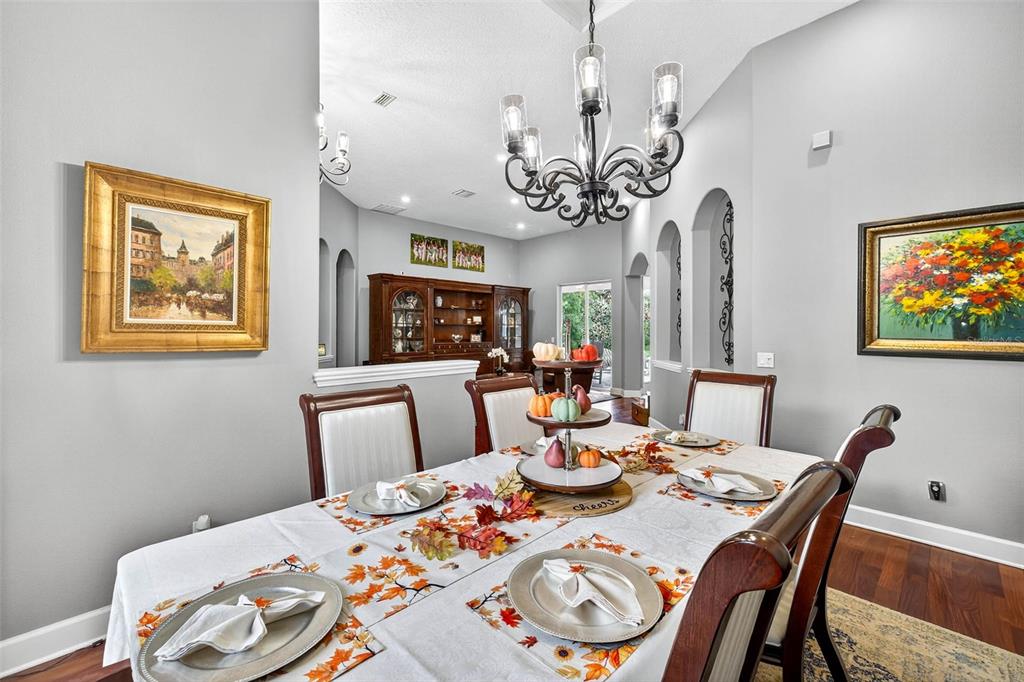 13887 Gavin Road Dover, FL 33527 - Photo 17 of 74 a view of a dining room with furniture a chandelier and wooden floor