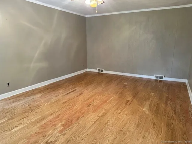 a view of an empty room with wooden floor