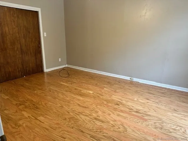 a view of an empty room with wooden floor