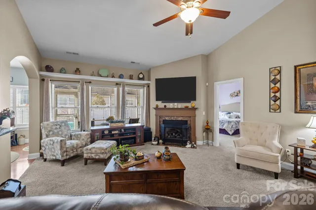 a living room with furniture a fireplace and a flat screen tv