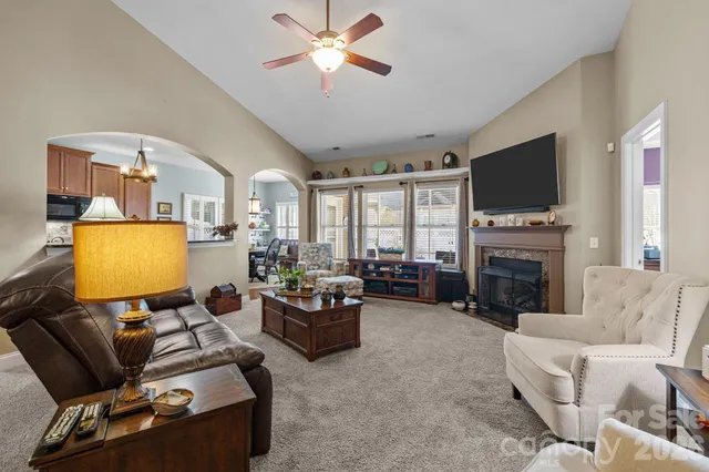 a living room with furniture a fireplace and a flat screen tv