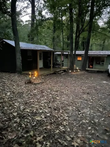 a backyard of a house with barbeque oven a fountain and a tree