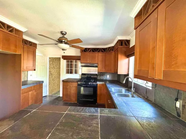 a kitchen with stainless steel appliances kitchen island granite countertop a sink and a refrigerator