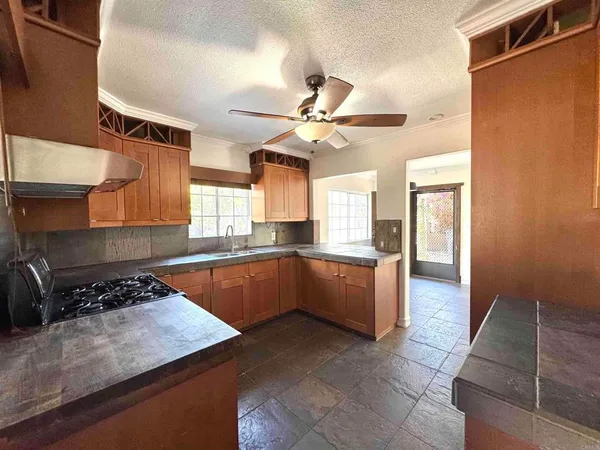 a kitchen with stainless steel appliances a sink a stove a refrigerator cabinets and a dining table