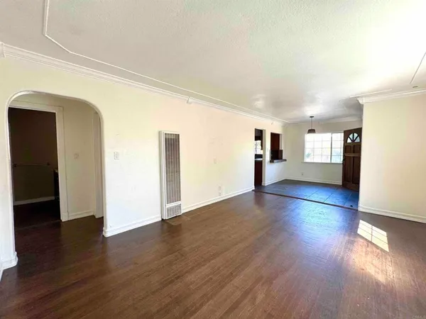 an empty room with wooden floor and fireplace