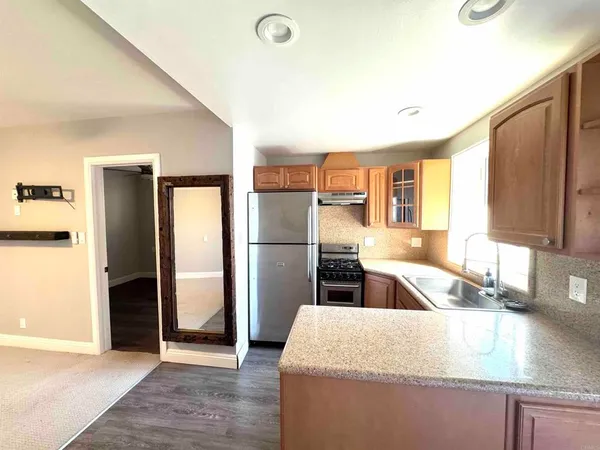 a kitchen with granite countertop a refrigerator and a sink