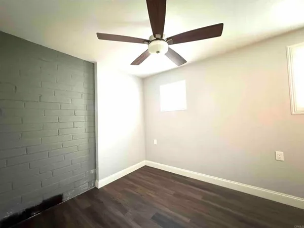 a view of a small space with wooden floor and a ceiling fan