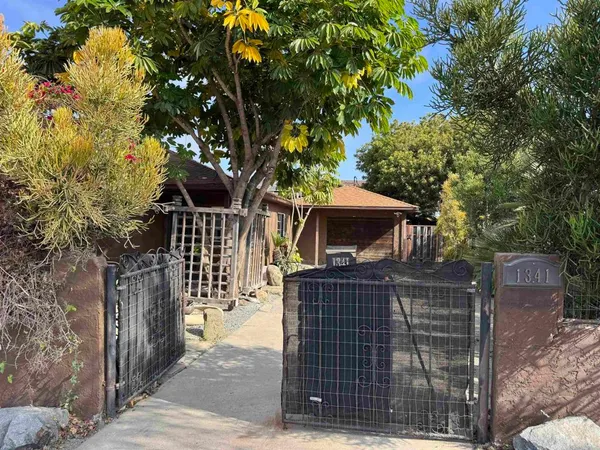 a front view of a house with a tree