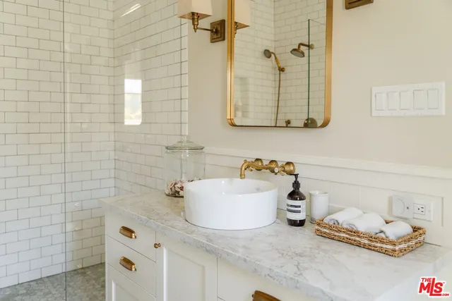 a bathroom with a granite countertop sink a toilet and shower