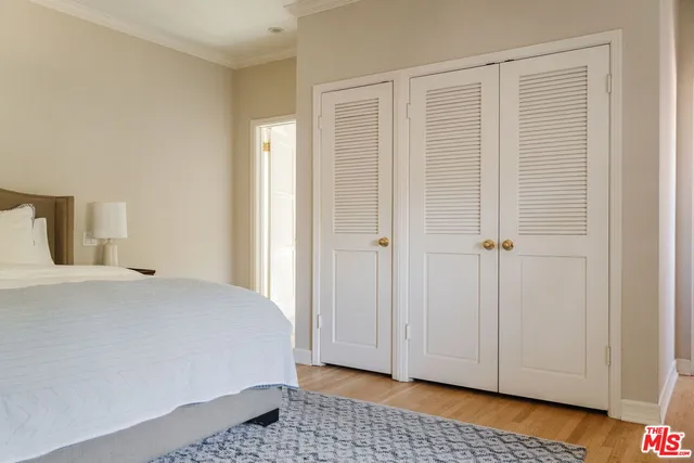 a bedroom with a white bed and wooden floor