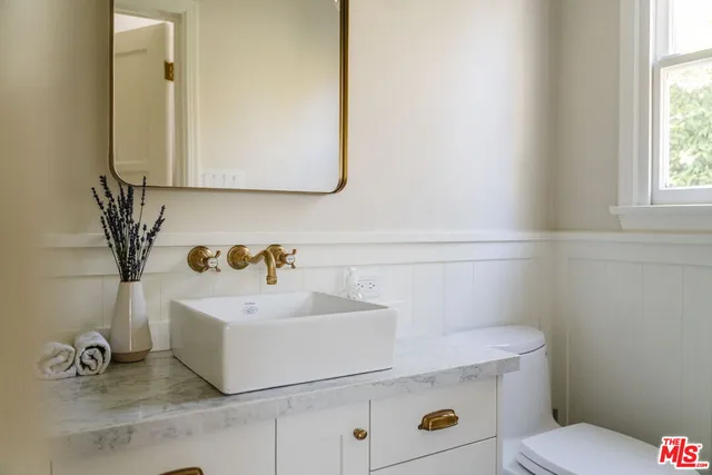 a bathroom with a sink a toilet and mirror