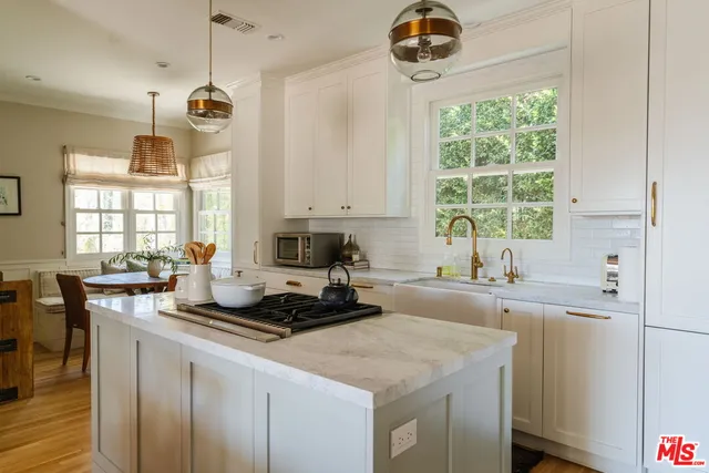 a kitchen with a sink a stove a microwave a dining table and chairs