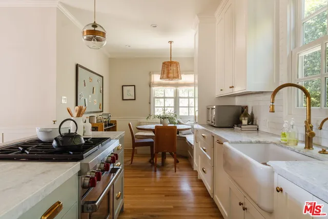 a kitchen with sink a stove and chairs
