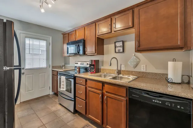 a kitchen with stainless steel appliances granite countertop a sink stove and cabinets