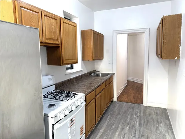 a kitchen with stainless steel appliances granite countertop a stove a sink and a refrigerator