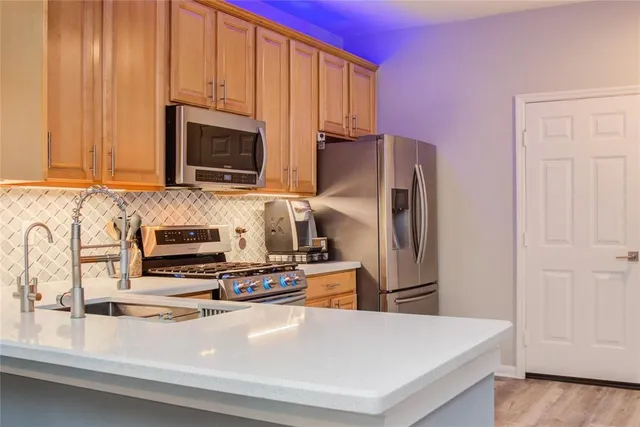a kitchen with stainless steel appliances a stove microwave and sink