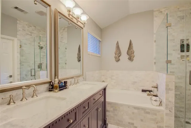 a bathroom with a tub sink and mirror