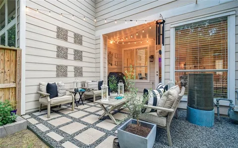 a view of a patio with couches table and chairs and potted plants