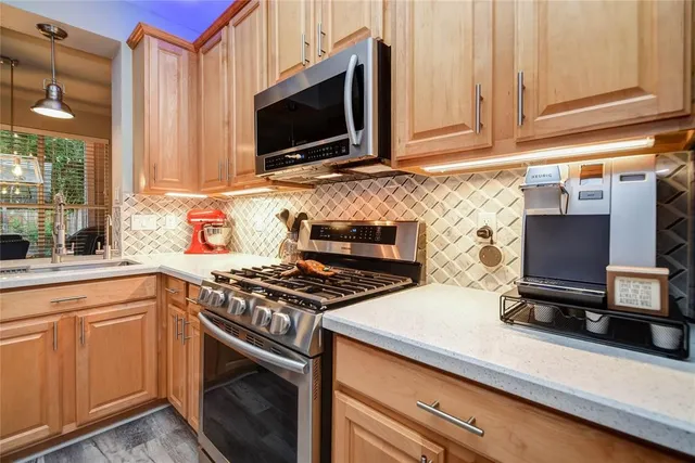 a kitchen with stainless steel appliances a stove a microwave and sink