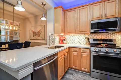 a kitchen with stainless steel appliances a stove a microwave a sink and cabinets