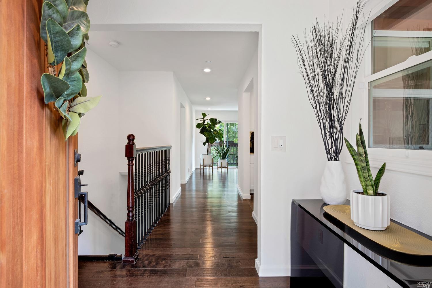 a view of a hallway with wooden floor and glass windows