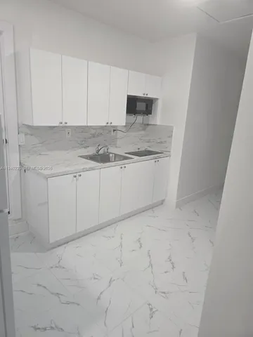 a bathroom with granite countertop cabinets and sink