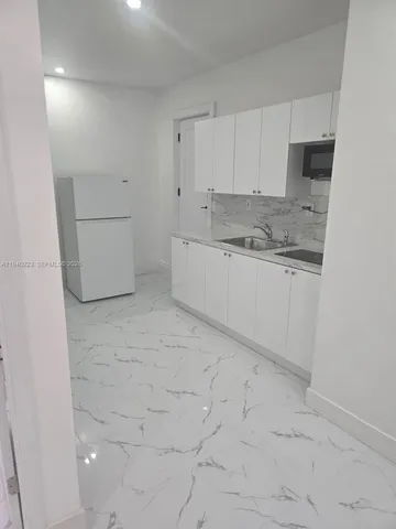 a kitchen with granite countertop white cabinets and white appliances