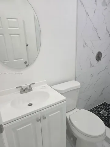 a bathroom with a sink a toilet and a mirror