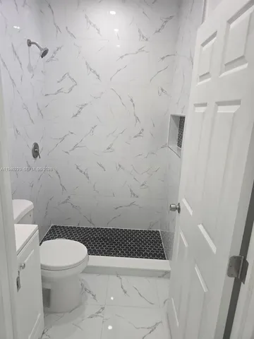 a bathroom with a toilet and a shower
