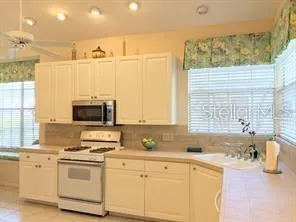 a kitchen with stainless steel appliances white cabinets a sink and a stove