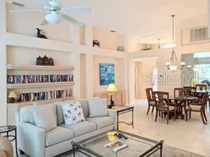 a living room with furniture kitchen view and a chandelier