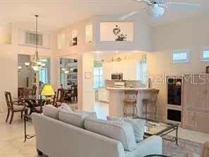 a living room with furniture a chandelier and a dining table