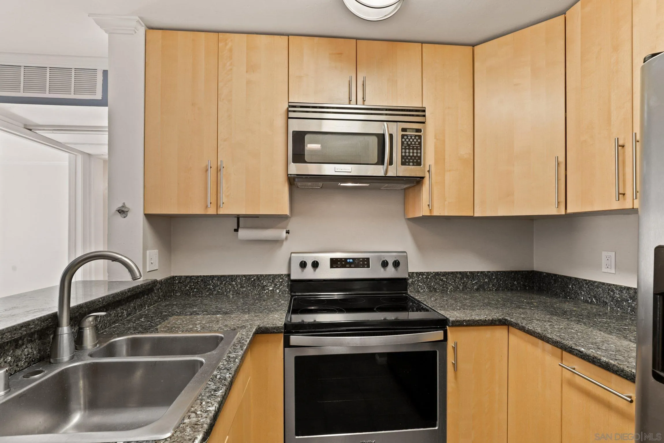 6757 Friars Road, Unit 13 San Diego, CA 92108 - Photo 5 of 15 a kitchen with granite countertop a stove sink and cabinets