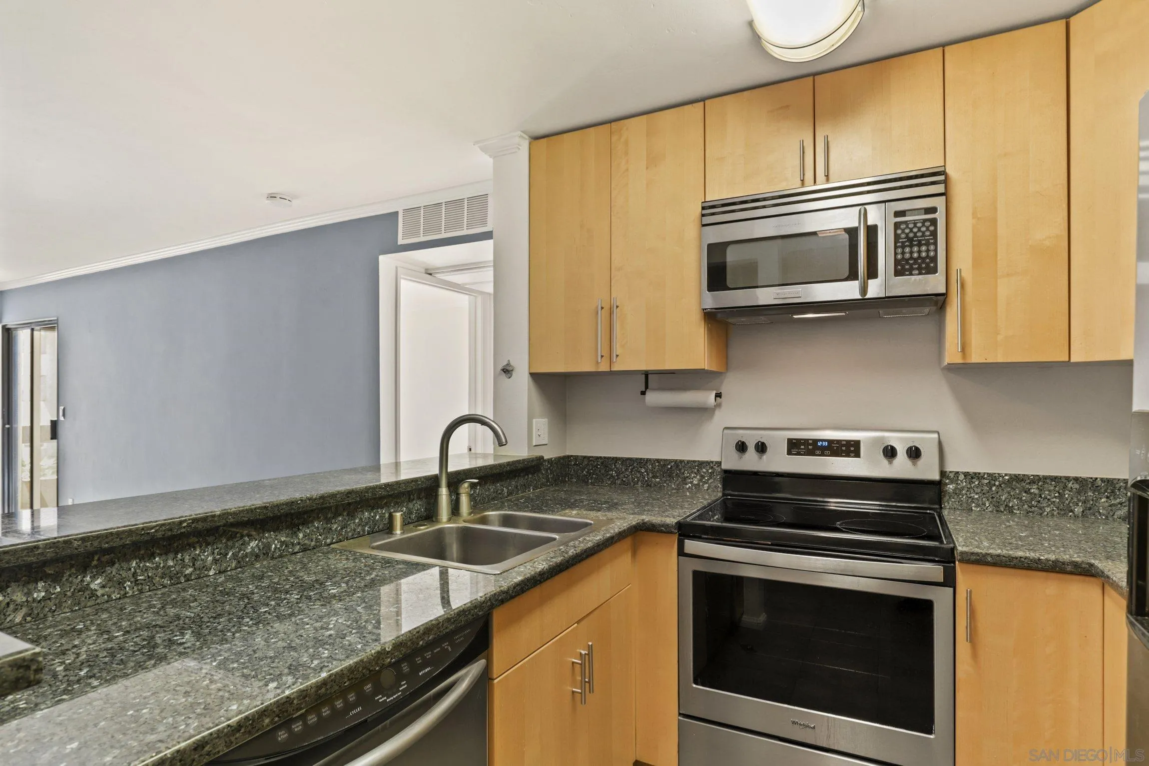6757 Friars Road, Unit 13 San Diego, CA 92108 - Photo 6 of 15 a kitchen with stainless steel appliances granite countertop a sink stove and microwave