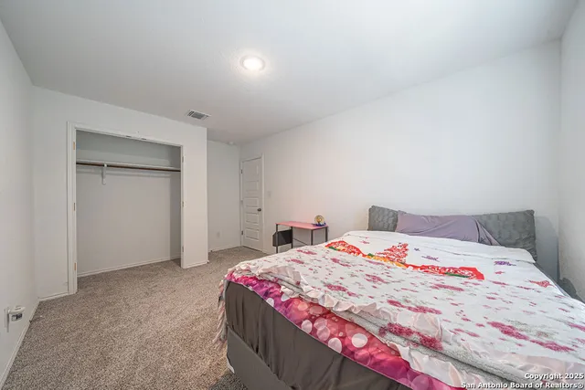 a spacious bedroom with a bed and window