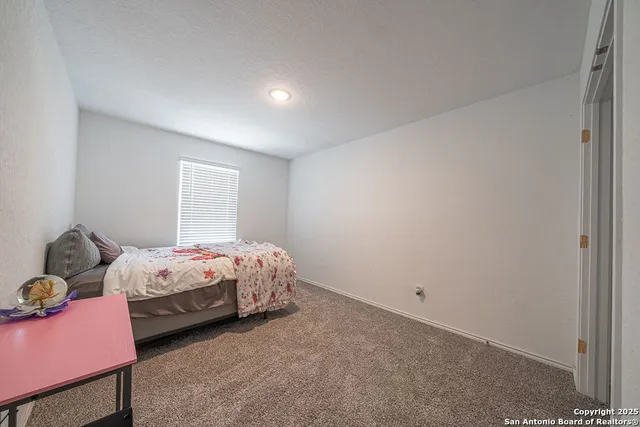 a spacious bedroom with a bed and a flat screen tv
