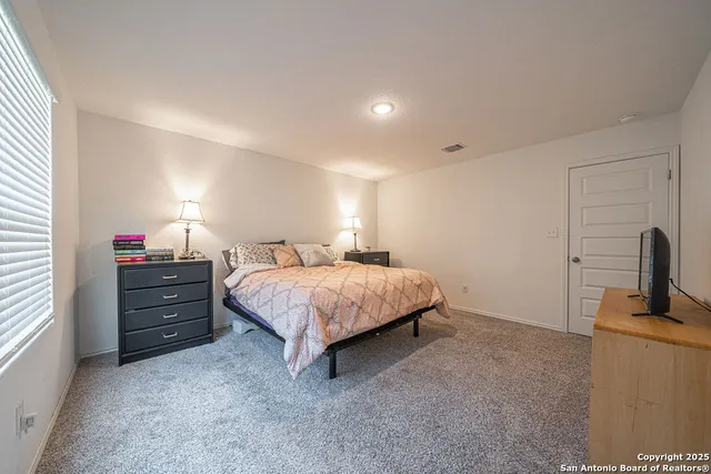 a spacious bedroom with a bed and a window