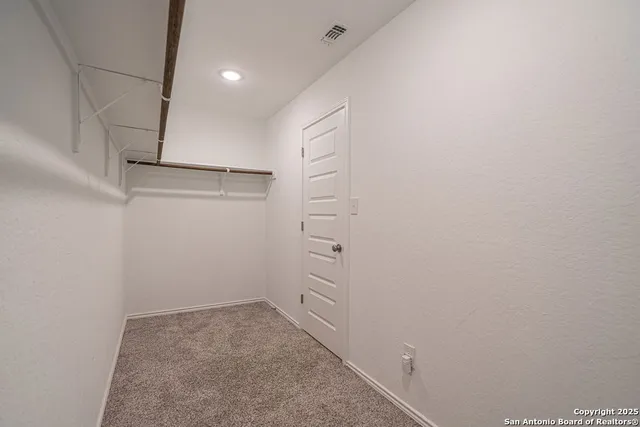 a view of a house with a large tree and wooden fence