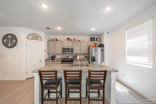 a kitchen with stainless steel appliances granite countertop a refrigerator and a stove