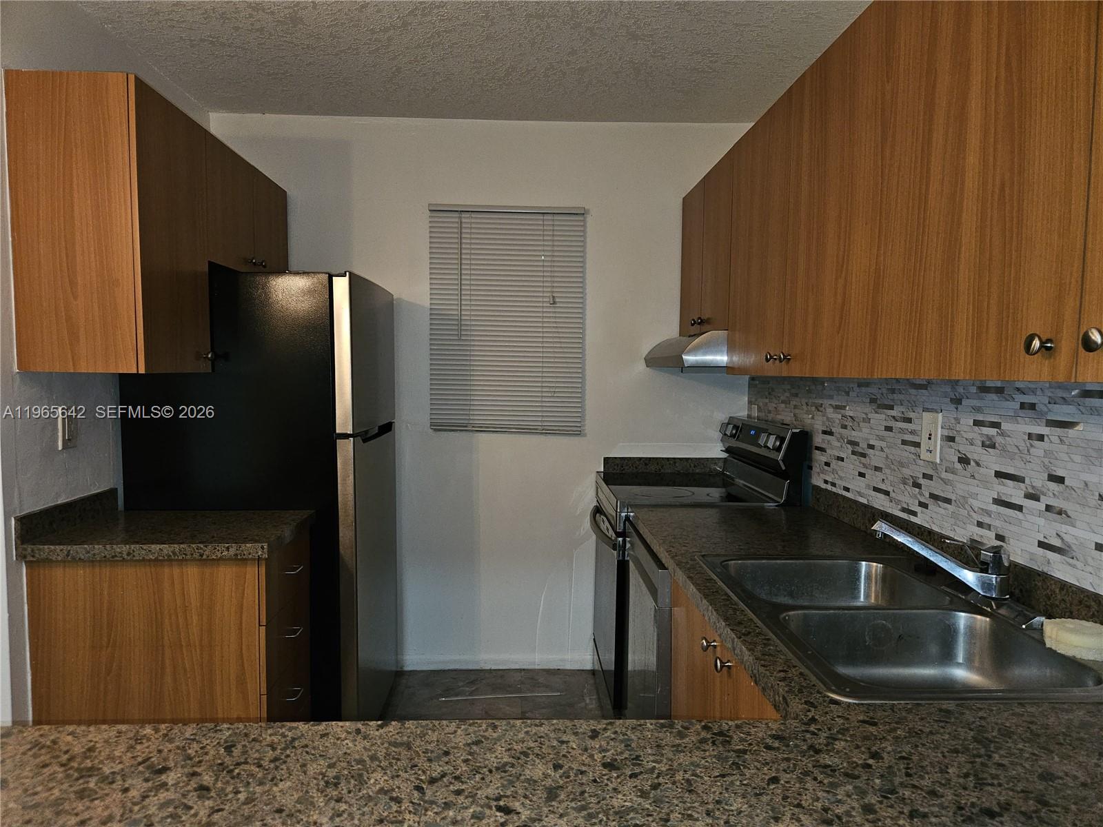 7610 Stirling Road, Unit 102C Davie, FL 33024 - Photo 5 of 11 a kitchen with a sink stove and refrigerator