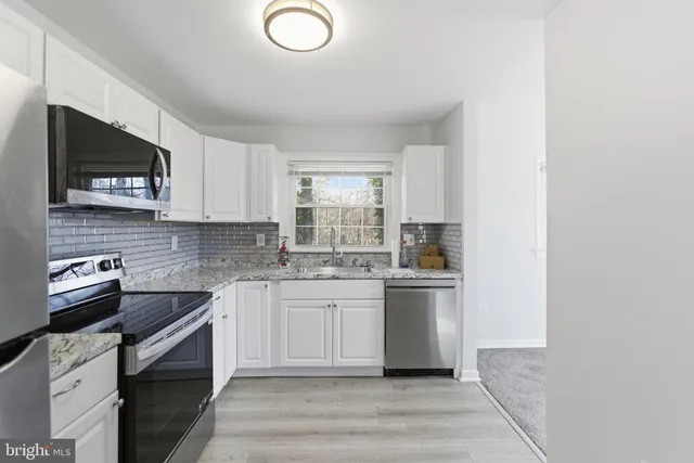 a kitchen with a sink stove and microwave
