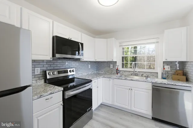 a kitchen with a sink stove and microwave