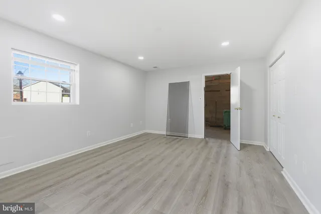 an empty room with wooden floor and a window