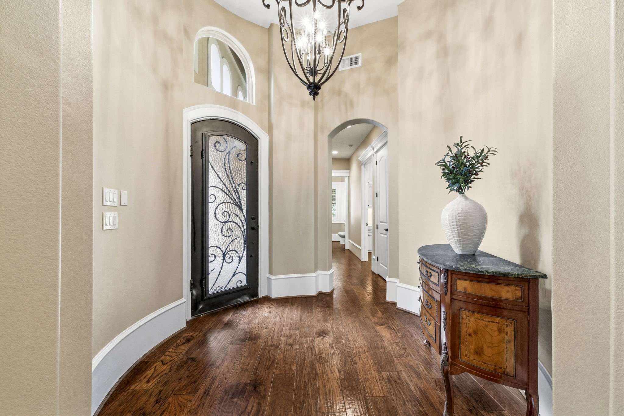 27402 Jacob's Path Lane Spring, TX 77386 - Photo 10 of 48 The entryway/foyer features elegant wood flooring, a decorative wrought iron front door, accented with a bronzed iron chandelier. The curved walls and arched doorways add a touch of sophistication has a welcoming ambiance.
