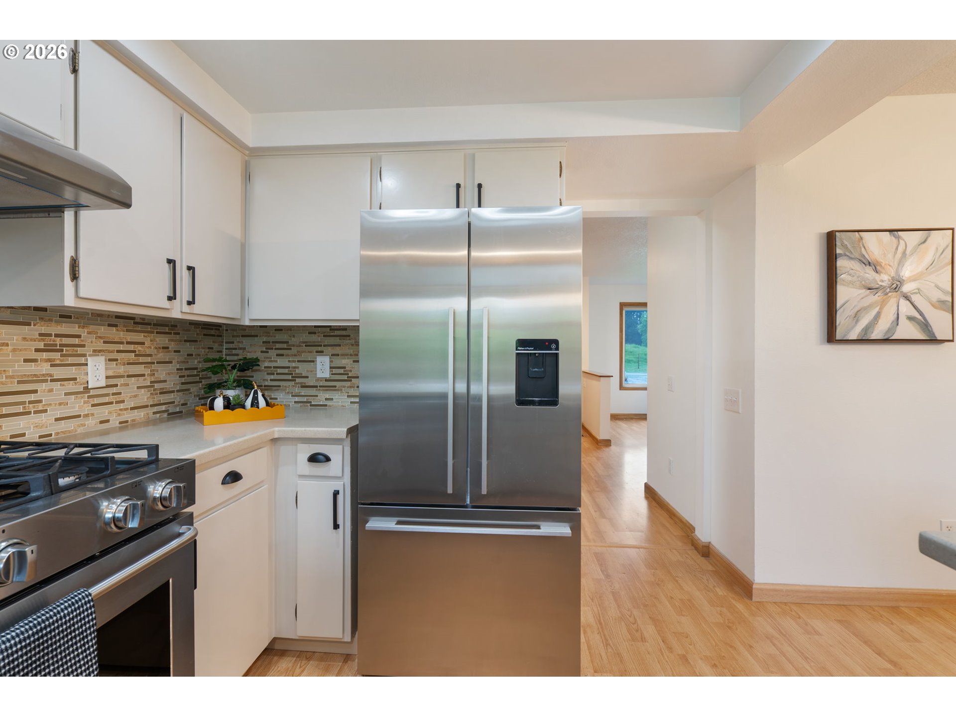 24950 Airport Road Northeast Aurora, OR 97002 - Photo 12 of 44 a kitchen with stainless steel appliances granite countertop a refrigerator a stove and a sink with wooden floor