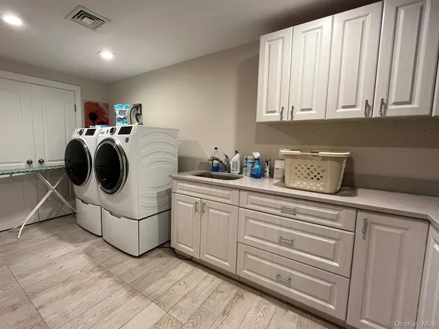 a utility room with sink dryer and washer