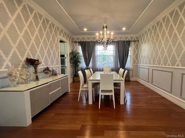 a dining room with furniture a chandelier and wooden floor