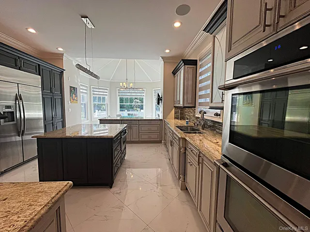 a kitchen with stainless steel appliances granite countertop a sink a stove and a refrigerator