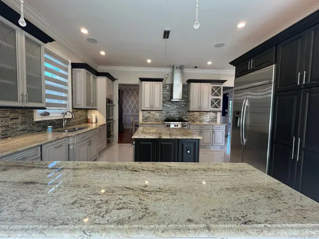 a large kitchen with granite countertop a large counter top stainless steel appliances and cabinets